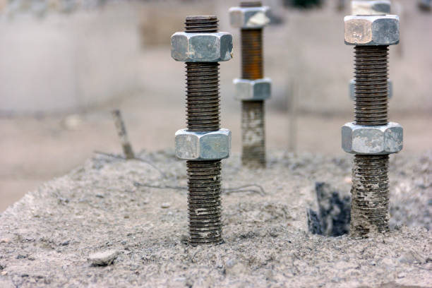 View of the the anchor bolts and nuts in the concrete foundation in the new industrial plant. View of the the anchor bolts and nuts in the concrete foundation in the new industrial plant. grill rods stock pictures, royalty-free photos & images