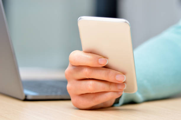 istock woman hand using a silver smartphone 1070003890