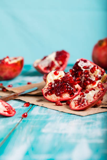 istock Pomegranate fruit on a cyan wooden surface. 1070008972