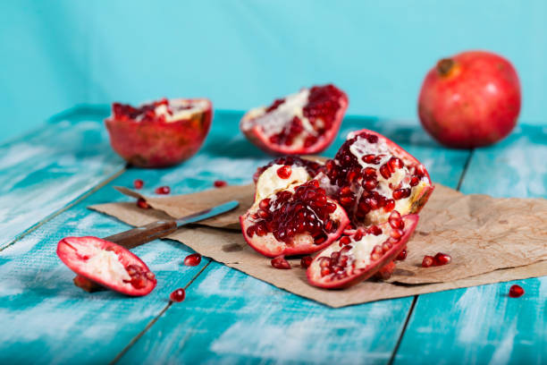 istock Pomegranate fruit on a cyan wooden surface. 1070009046