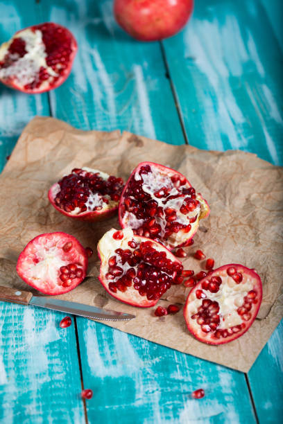 istock Pomegranate fruit on a cyan wooden surface. 1070009336