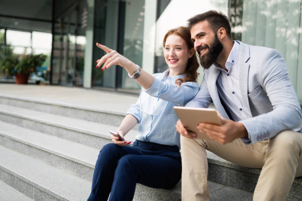 istock Business man and woman working outdoors with tablet computer in front of office 1070010306