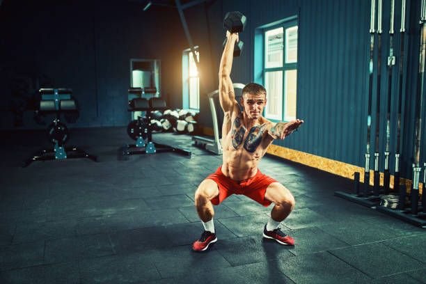 istock Athletic man works out at the gym with a barbell 1070011776