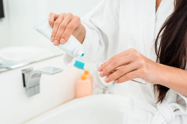 istock close up of female hands adding toothpaste on toothbrush 1070011908