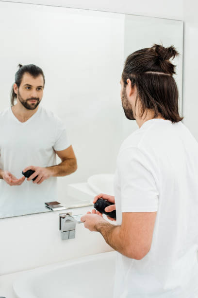 istock Man holding shaving foam and looking in mirror 1070012208