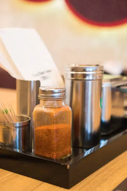 Photo of condiments on dining table like salt, pepper, spice, sauces