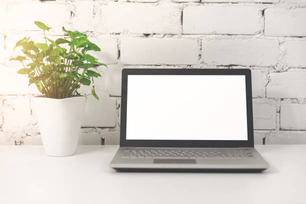 istock laptop with blank screen in front of white brick wall 1070022724