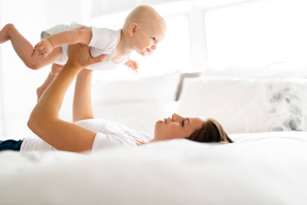 istock mother with baby on bed having good time 1070025670