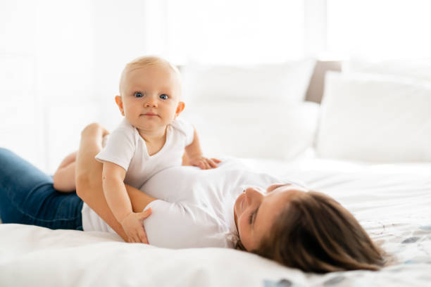 istock mother with baby on bed having good time 1070025682