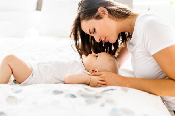 istock mother with baby on bed having good time 1070026090