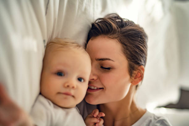 istock mother with baby on bed having good time 1070026266