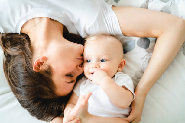 istock mother with baby on bed having good time 1070026426