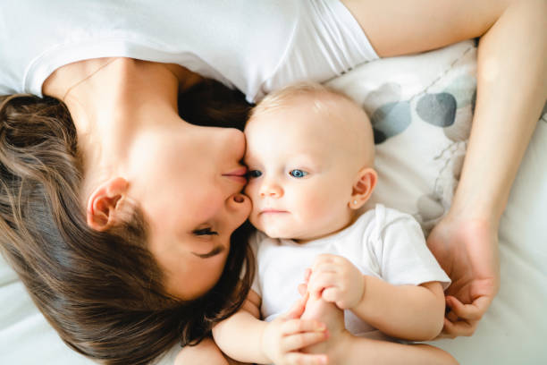 istock mother with baby on bed having good time 1070026576
