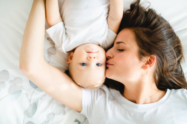 istock mother with baby on bed having good time 1070026754