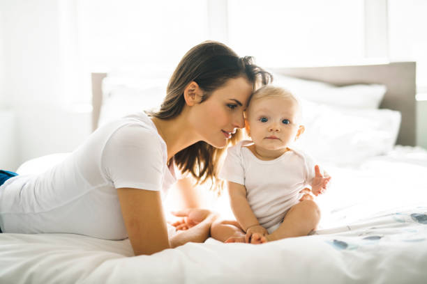 istock mother with baby on bed having good time 1070026986