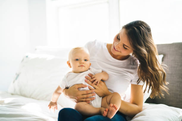 istock mother with baby on bed having good time 1070027020