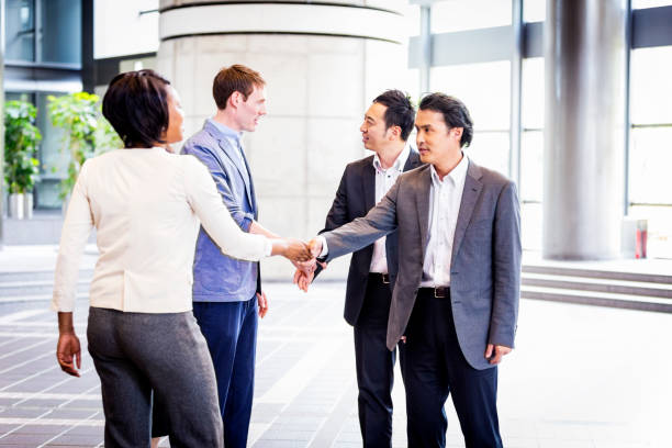 zróżnicowane kierownictwo biznesu powitanie w ich lobby biura - handshake respect japan business zdjęcia i obrazy z banku zdjęć