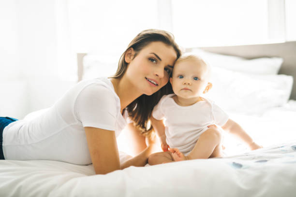 istock mother with baby on bed having good time 1070027068