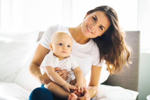 istock mother with baby on bed having good time 1070027280