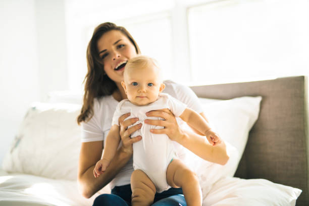 A happy mother with baby on bed