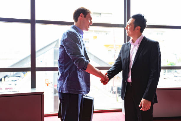 japoński business executives spotkanie europejskiego biznesmena - handshake respect japan business zdjęcia i obrazy z banku zdjęć