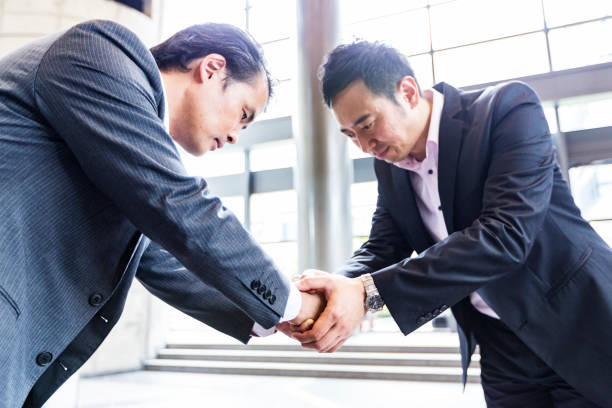 istock Japanese Business Executives Bowing and Shaking Hands 1070028896