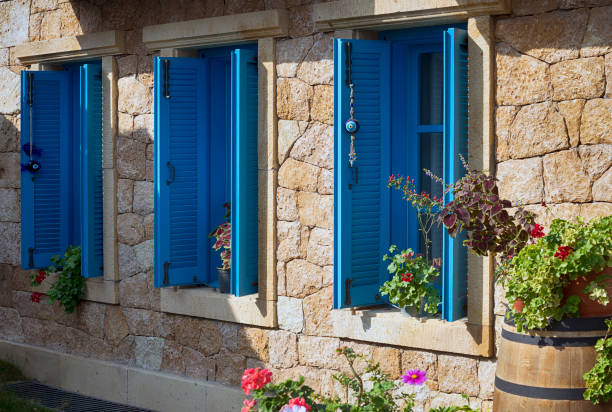 Beautiful vintage window with open blue shutters Vintage window with shutters that open and fresh flowers with stone wall stonewall creek stock pictures, royalty-free photos & images