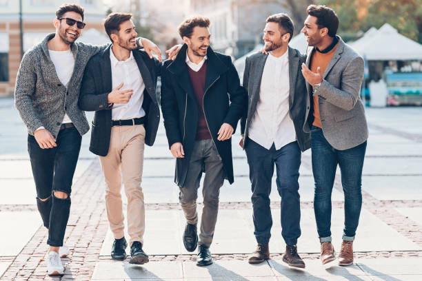 Group of cheerful male friends on the street Group of male friends walking outdoors in the city stag night stock pictures, royalty-free photos & images