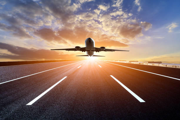 istock Asphalt road and sky flying airplane at sunset 1070030572