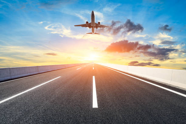 istock Asphalt road and sky flying airplane at sunset 1070030676