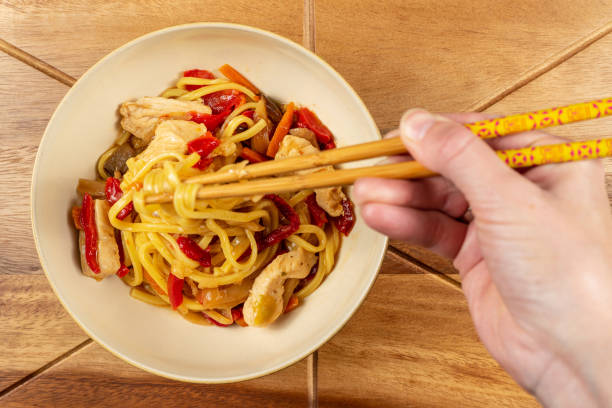 istock Chicken chow mein and chopsticks on wooden table 1070030796