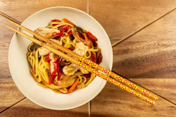 istock Chicken chow mein and chopsticks on wooden table 1070030798