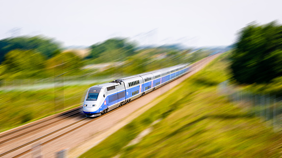 Moisenay, France - August 23, 2017: A double-decker TGV Duplex high speed train in Atlantic livery from french company SNCF driving at full speed in the countryside (artist's impression with digital enhancement).