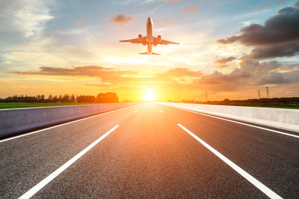istock Asphalt road and sky flying airplane at sunset 1070032184