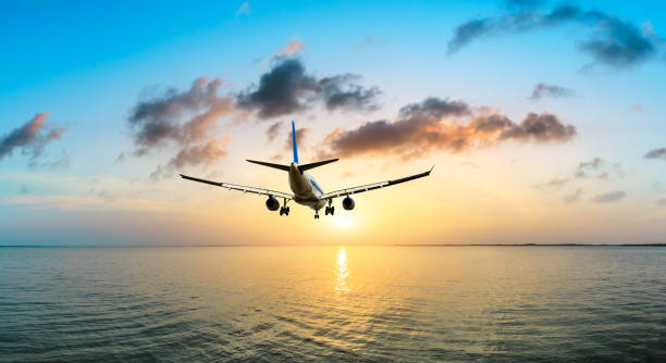 istock Airplane flying over the sea at sunset 1070032530