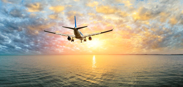 istock Airplane flying over the sea at sunset 1070032602