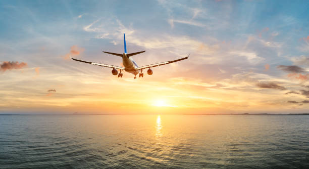 istock Airplane flying over the sea at sunset 1070032604