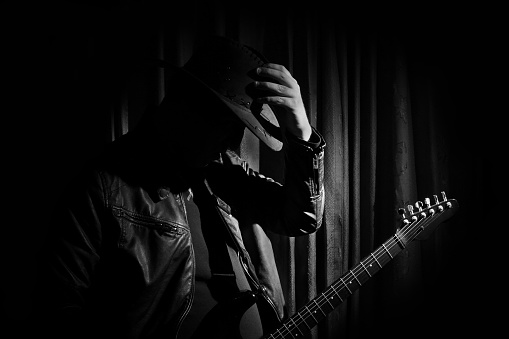 Silhouette of guitar player. Portrait of guitarist . Music concept, guitarist in dark. Black and white photo.