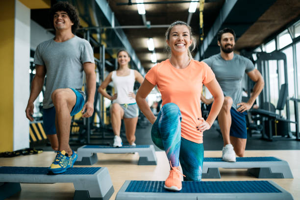 Group of young people doing exercises in gym Group of young people doing exercises together in gym gym group class stock pictures, royalty-free photos & images