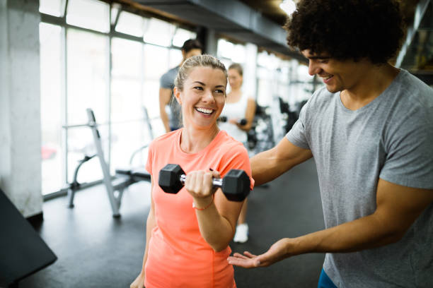 istock Young beautiful woman doing exercises with personal trainer 1070035340