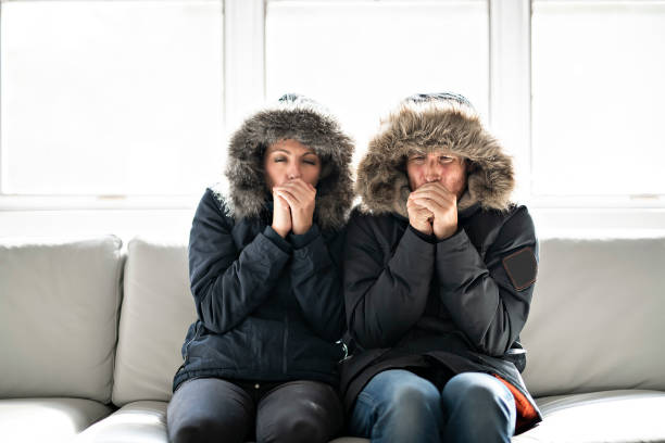 istock Couple have cold on the sofa at home with winter coat 1070035710