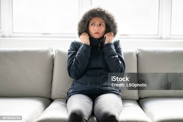 Woman Have Cold On The Sofa At Home With Winter Coat Stock Photo - Download Image Now