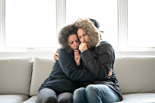 istock Couple have cold on the sofa at home with winter coat 1070035744