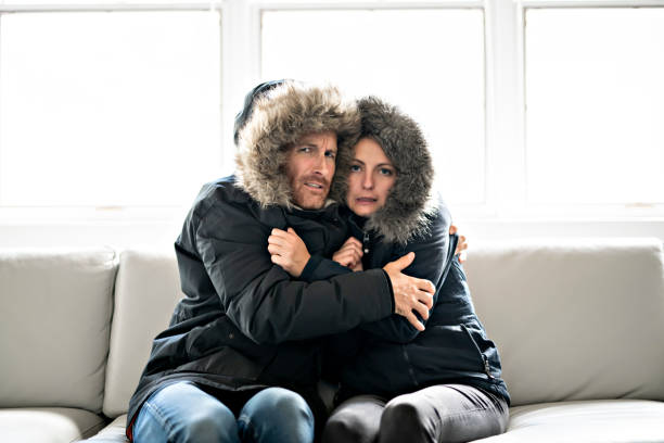 istock Couple have cold on the sofa at home with winter coat 1070035756