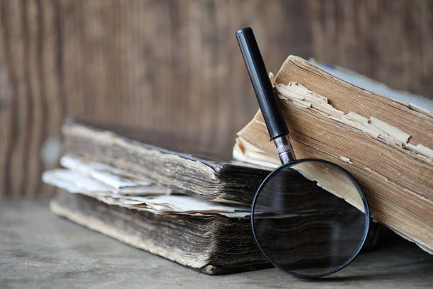 istock Old books on a wooden table and magnifier 1070038446