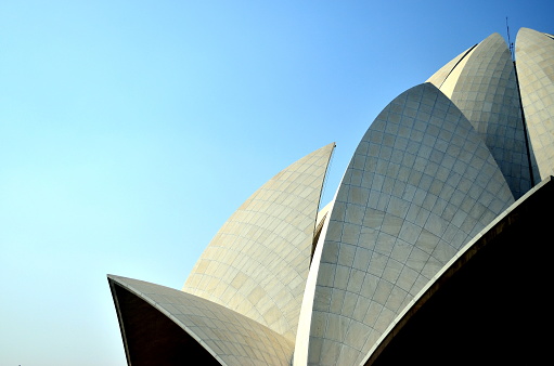 Left flank, Lotus Temple, a symbol of peace & harmony for all religions and faiths, it is a popular tourist destination in Delhi,India. Made from marble, it is most beautiful Bahai temple in the world. Circa 2018