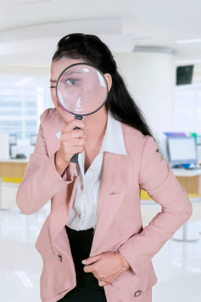 istock Female entrepreneur with magnifier in office 1070042504