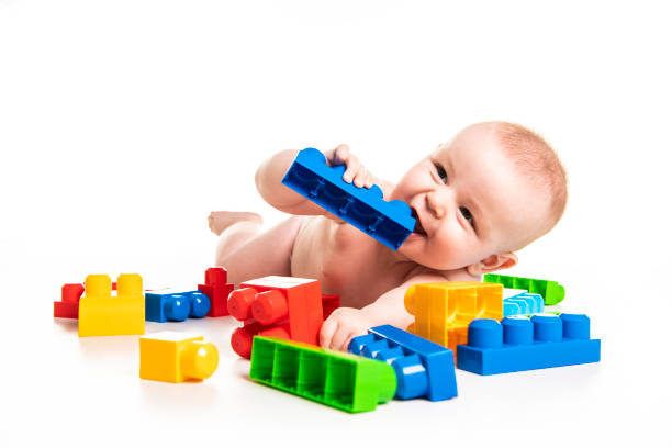 A Baby boy plays with toy blocks over white background