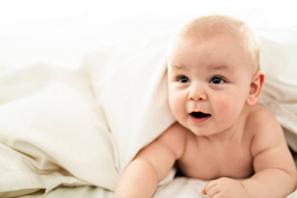 istock happy cute baby lying on white sheet 1070045178