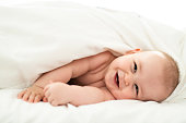 happy cute baby lying on white sheet